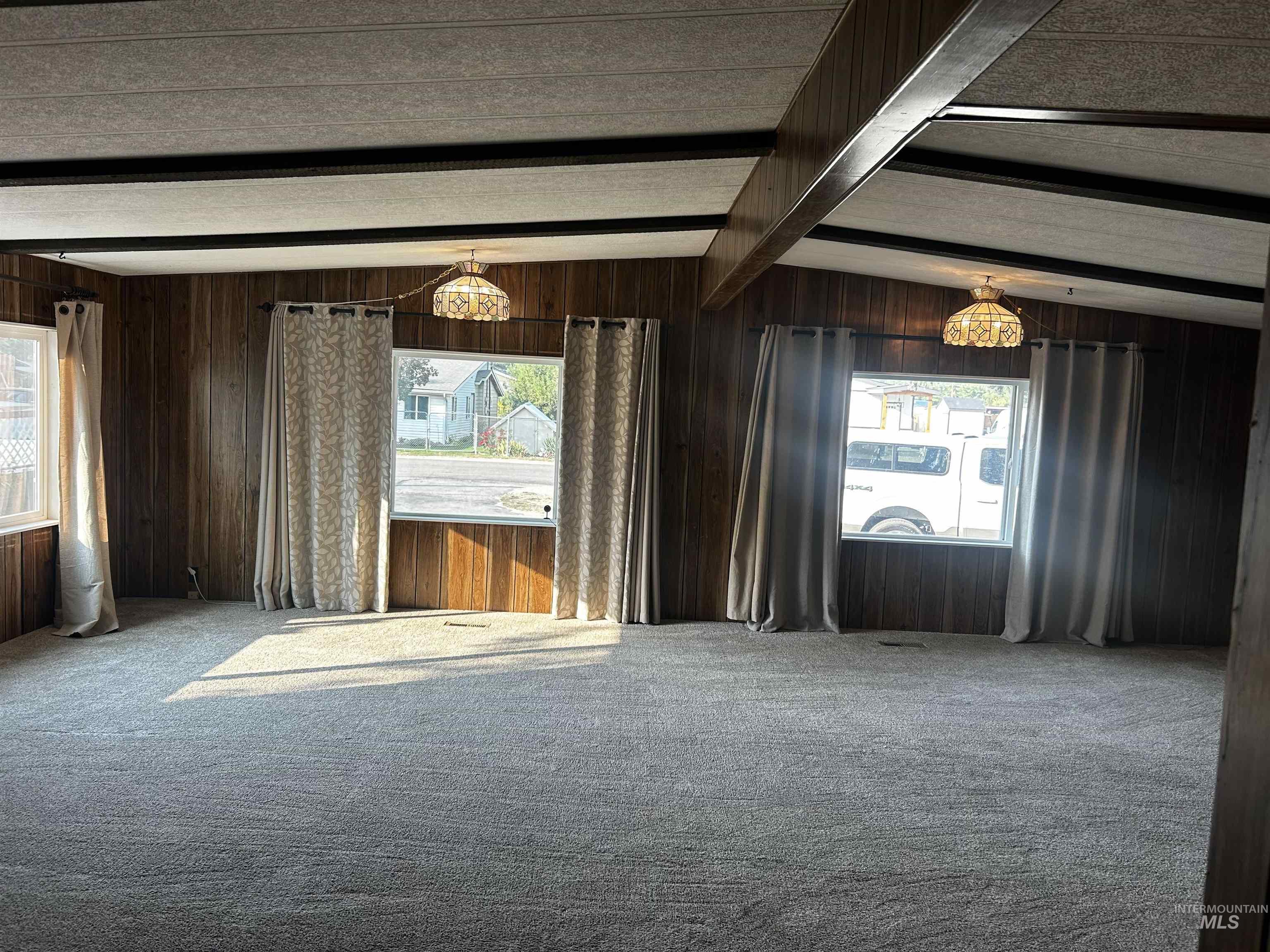 10165 West Claudia Road Boise, ID 83714 - Photo 16 of 30 Spacious room featuring wood-finish wall panels, overhead lighting, and carpet flooring