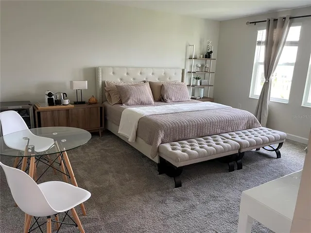 a bedroom with a bed a table and chair