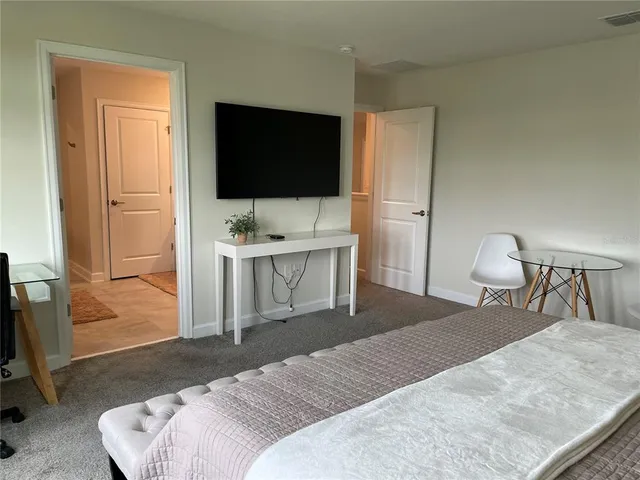 a bedroom with a bed and a flat screen tv