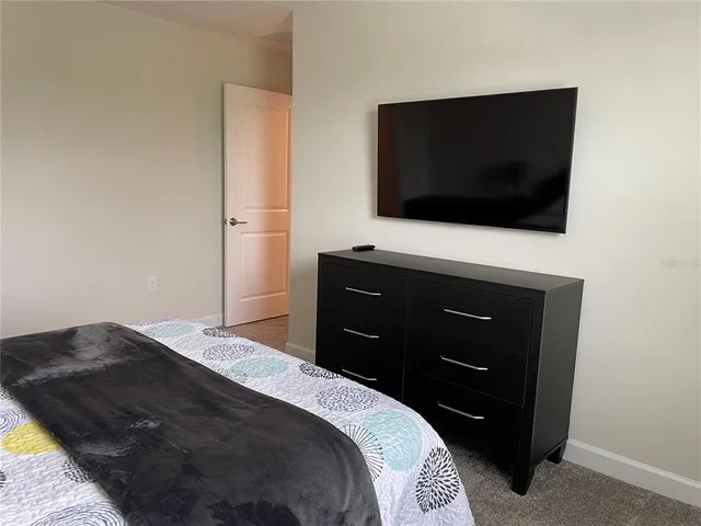 a bedroom with a bed and a flat screen tv