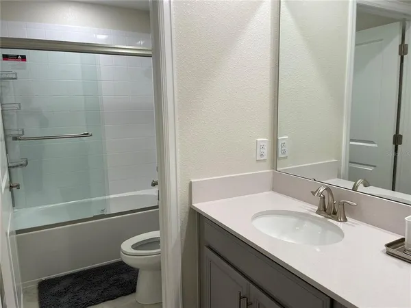 a bathroom with a sink toilet vanity and shower