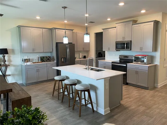 a kitchen with kitchen island a sink table and chairs
