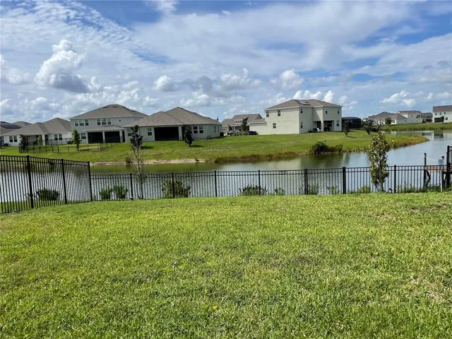 a view of house with a big yard and potted plants