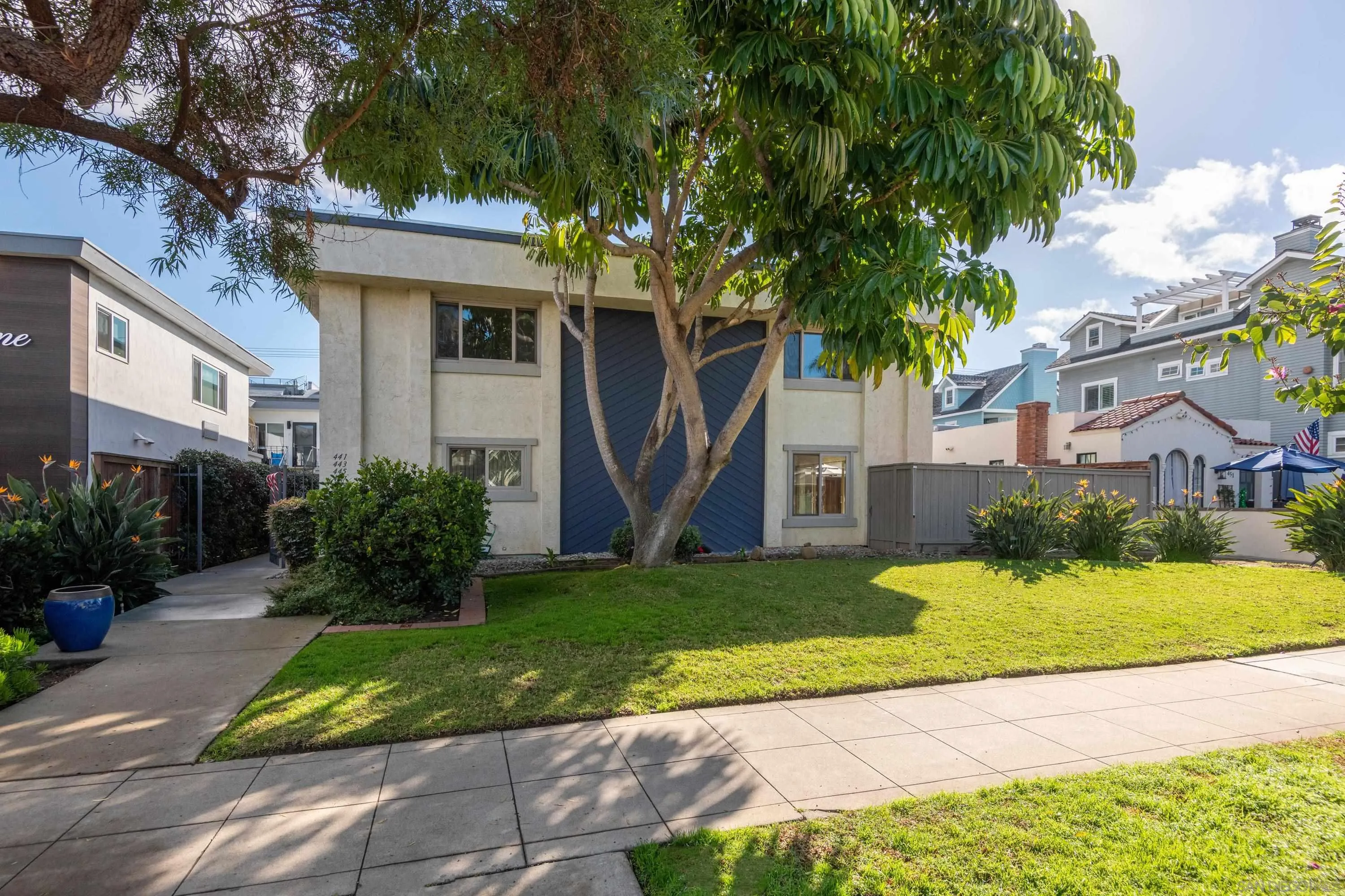 441 D Avenue Coronado, CA 92118 - Photo 21 of 24 a view of a white house next to a yard with plants and trees