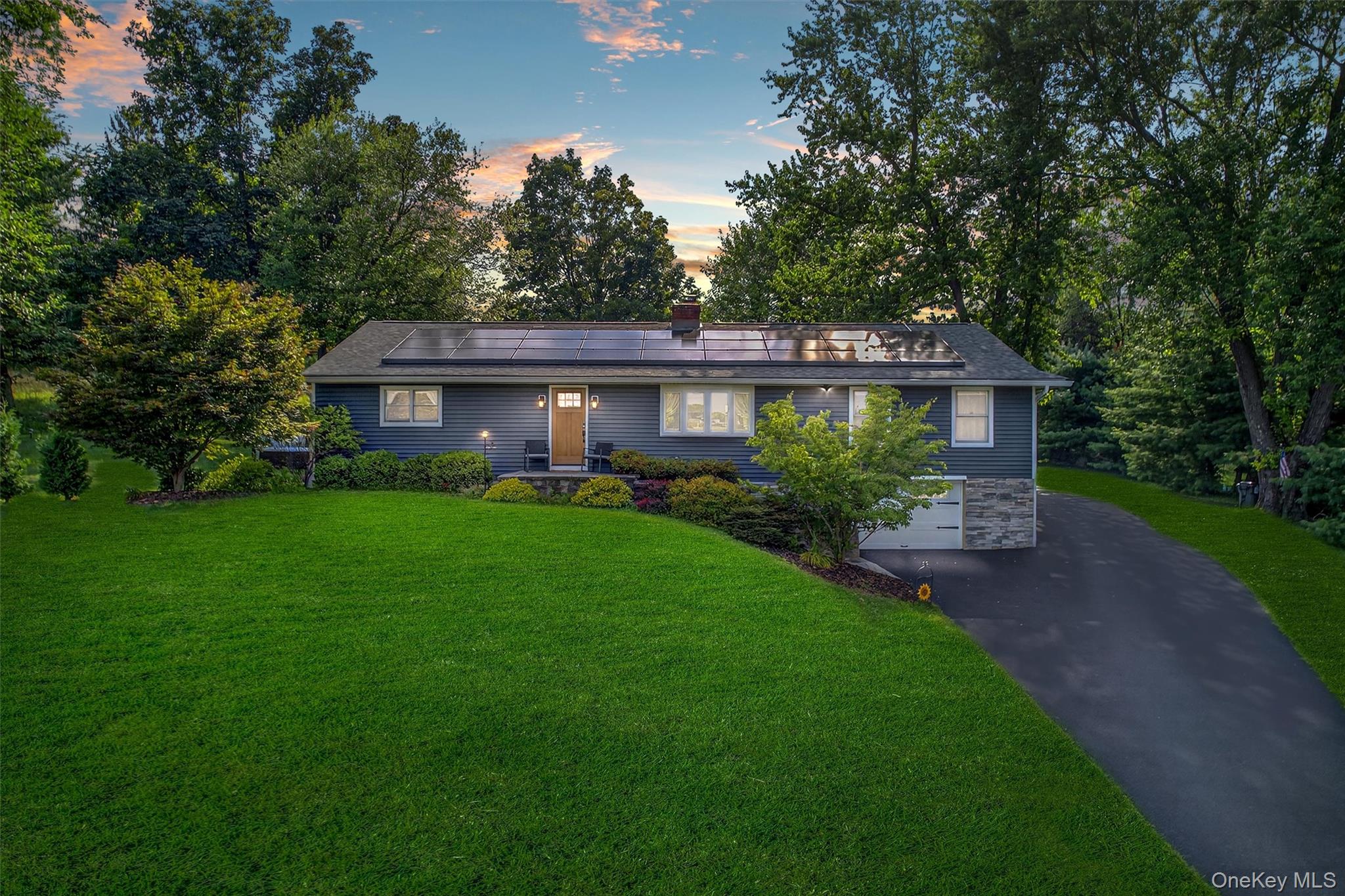 a front view of a house with a yard and green space