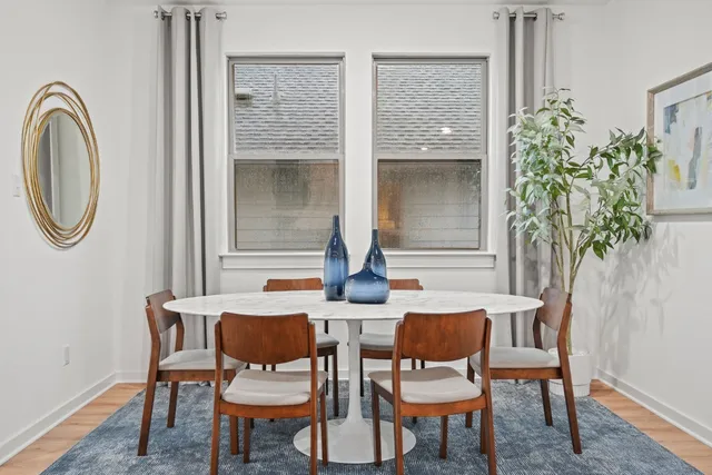 a dining room with furniture and a potted plant