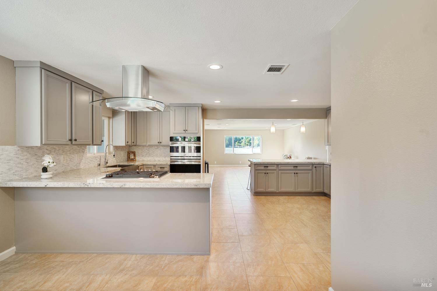 7208 Browns Valley Road Vacaville, CA 95688 - Photo 12 of 64 a large white kitchen with kitchen island a sink a center island stainless steel appliances and a cabinets