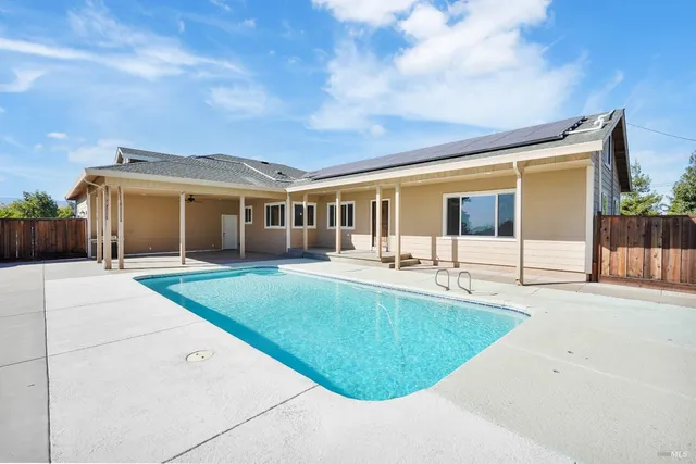 a view of house with backyard and seating area