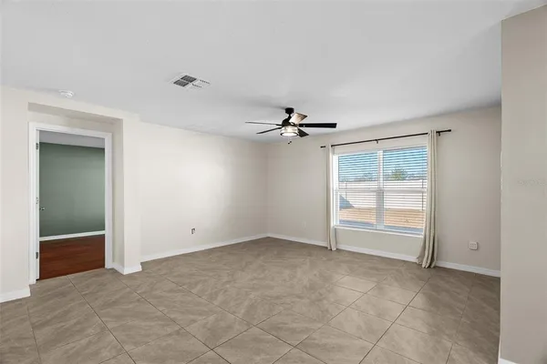 an empty room with windows and fan
