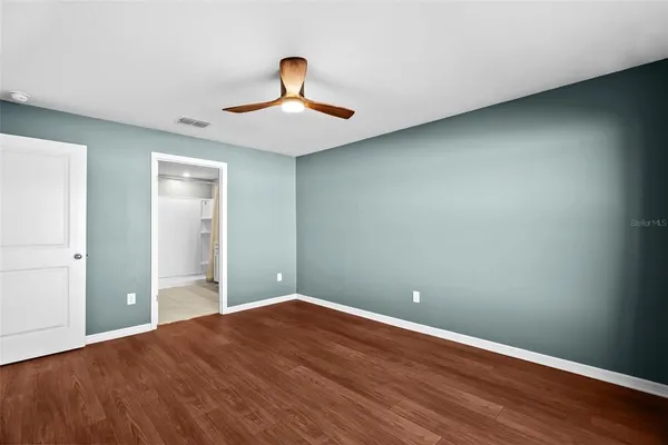 a view of an empty room with wooden floor