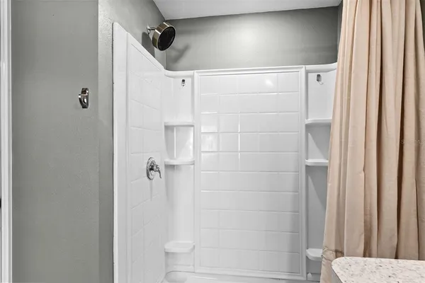 a bathroom with a shower and a glass door