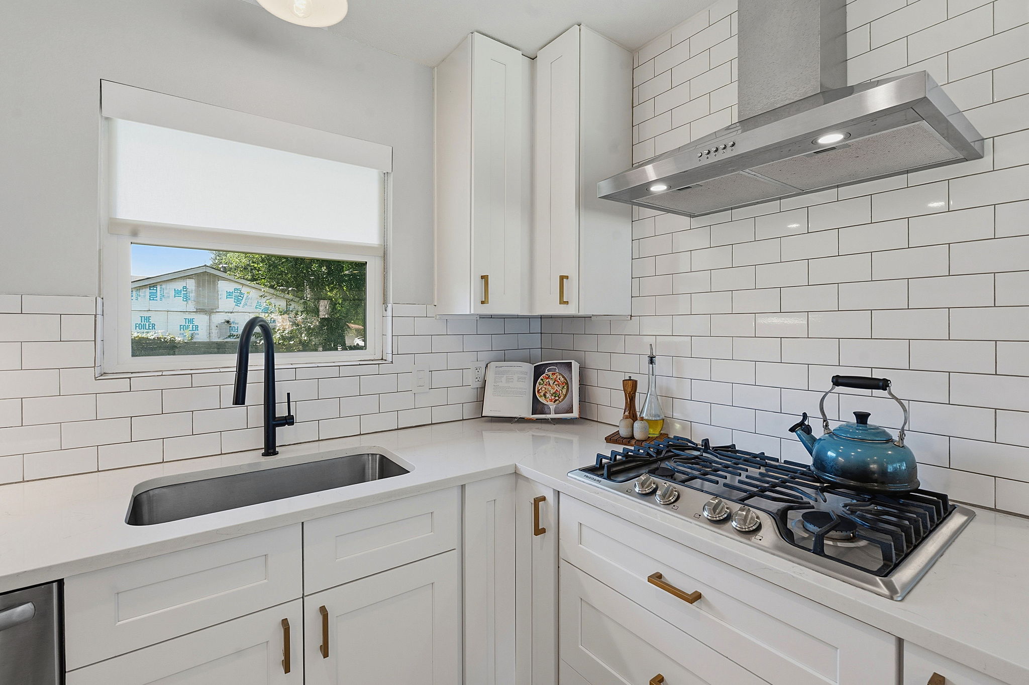 4403 Elmsgrove Drive Austin, TX 78721 - Photo 8 of 38 White subway tile backsplash complements a built-in gas range and under-mount sink.