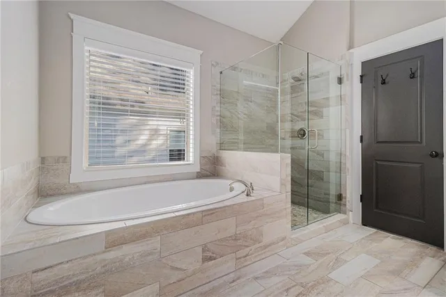 a spacious bathroom with a granite countertop tub toilet and a shower