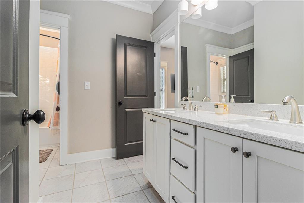 519 Holcomb Bridge Road Norcross, GA 30071 - Photo 22 of 31 a bathroom with a double vanity sink a mirror a vanity and a shower