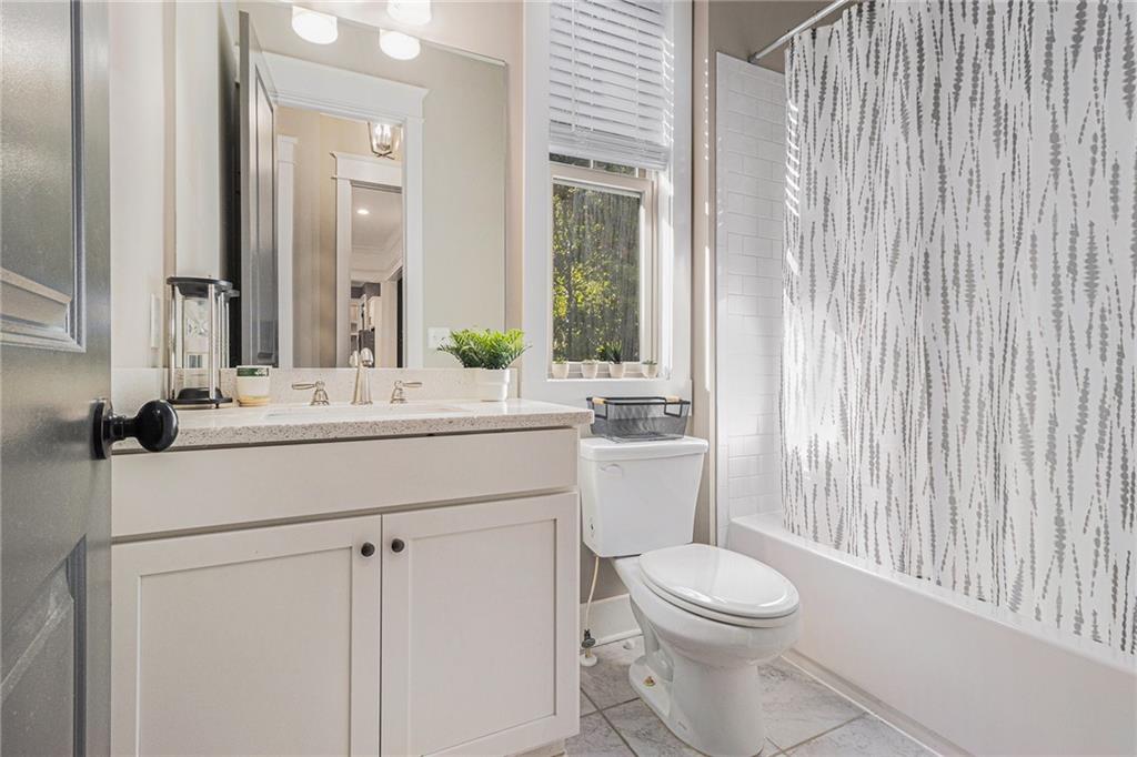 519 Holcomb Bridge Road Norcross, GA 30071 - Photo 23 of 31 a bathroom with a toilet a sink and mirror