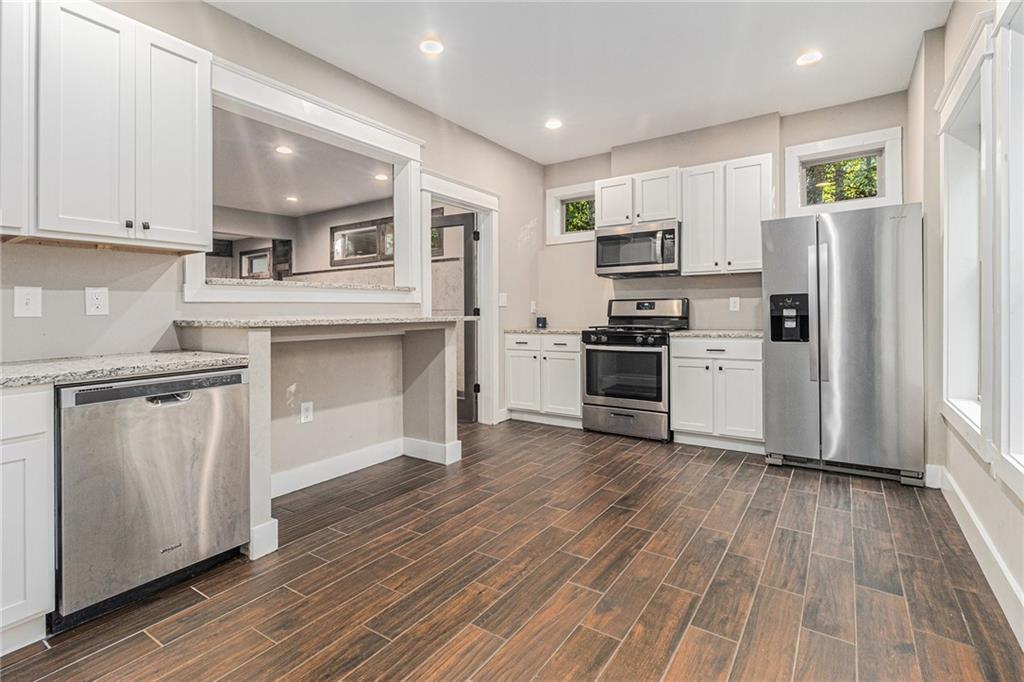 519 Holcomb Bridge Road Norcross, GA 30071 - Photo 25 of 31 a kitchen with granite countertop a refrigerator and a stove top oven