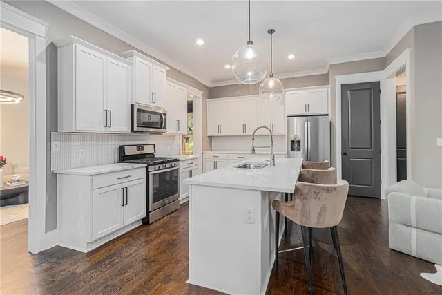 a kitchen with kitchen island a white cabinets and refrigerator