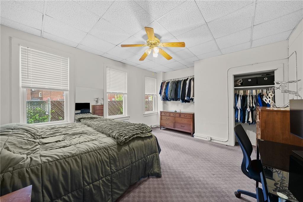 2016 Sidney Street Pittsburgh, PA 15203 - Photo 14 of 44 a spacious bedroom with a bed a dresser and a large window