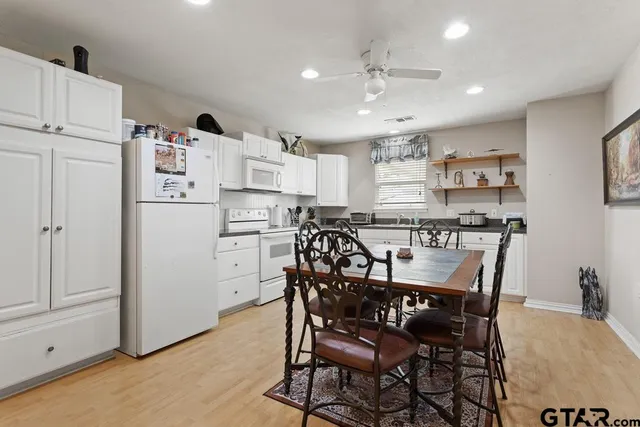 a dining room with kitchen island stainless steel appliances a table and chairs