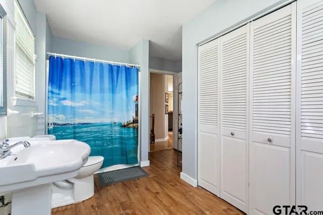 a bathroom with a sink a toilet and shower