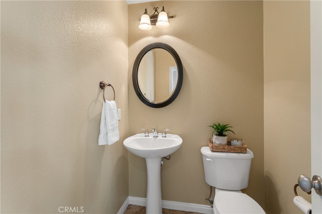 28817 Edenton Way Temecula, CA 92591 - Photo 16 of 56 a bathroom with a toilet a sink and a mirror