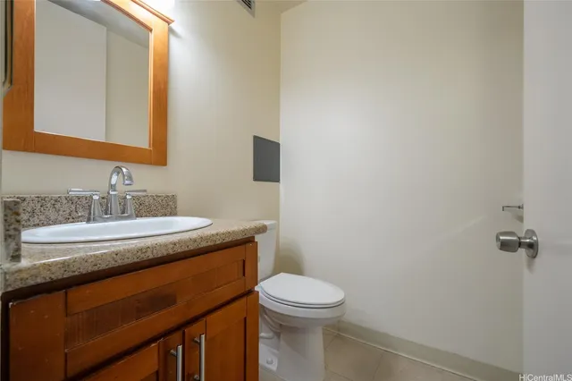 a bathroom with a granite countertop sink toilet and mirror