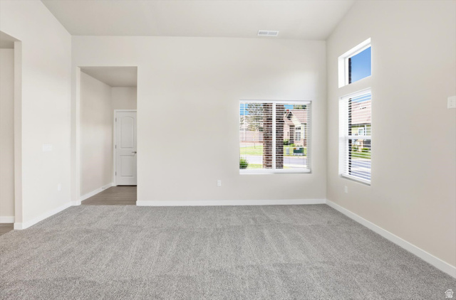 1838 West 300th Street South, Unit B Mapleton, UT 84664 - Photo 3 of 51 Living space with vaulted ceilings, light gray carpeting, multiple windows with blinds, a white door, and a recessed entryway