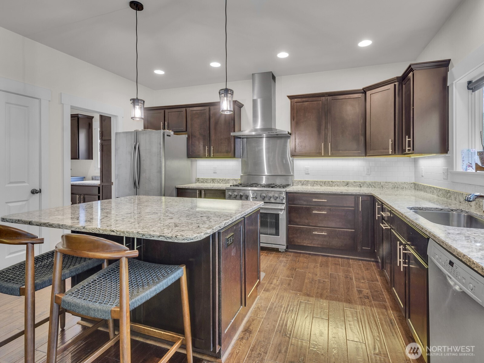 12503 Southeast 104th Street Renton, WA 98056 - Photo 14 of 37 a kitchen with granite countertop kitchen island stainless steel appliances a sink stove and refrigerator