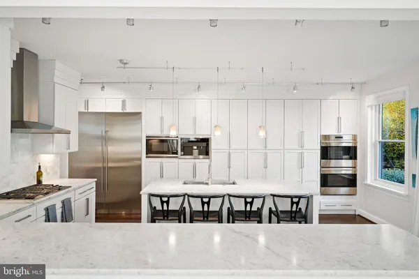 a kitchen with granite countertop a sink and a refrigerator