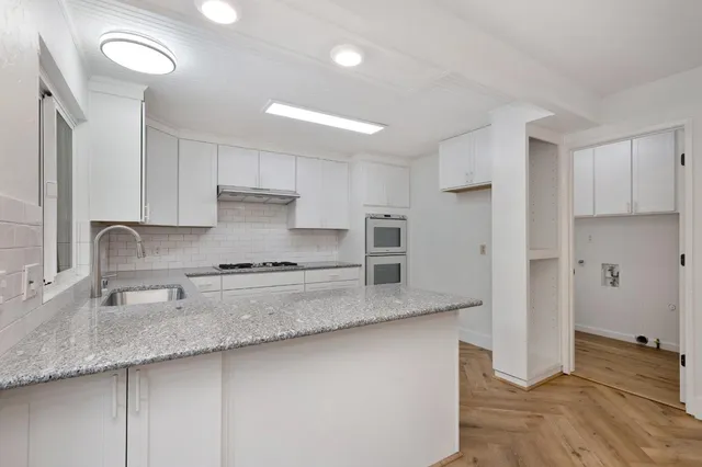 a kitchen with stainless steel appliances granite countertop a stove a sink and a refrigerator