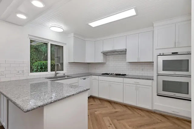 a kitchen with a sink cabinets and window