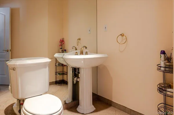 a bathroom with a toilet sink and mirror