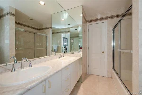 a bathroom with a double vanity sink mirror and shower