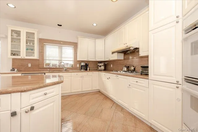 a kitchen with granite countertop white cabinets and white appliances