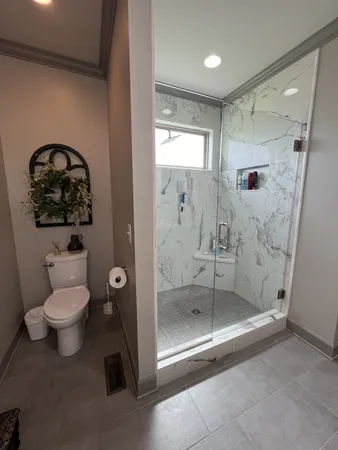a bathroom with a shower a toilet and a sink