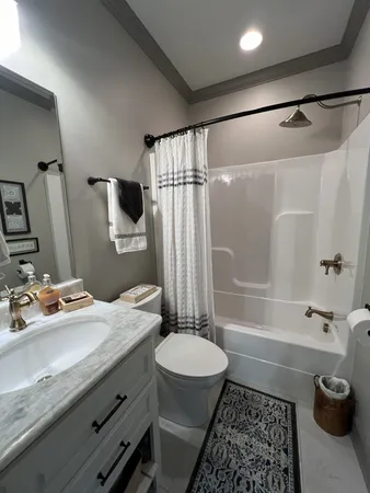 a bathroom with a granite countertop sink toilet and shower
