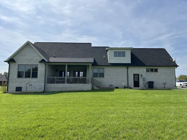 a view of a house with a yard and sitting area