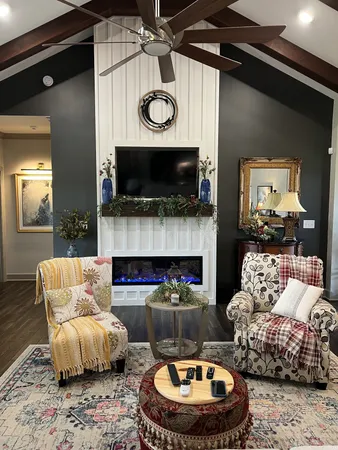 a living room with furniture a flat screen tv and a fireplace