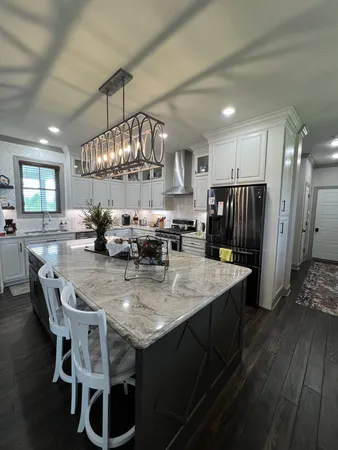 a view of a dining room and livingroom with furniture wooden floor a chandelier