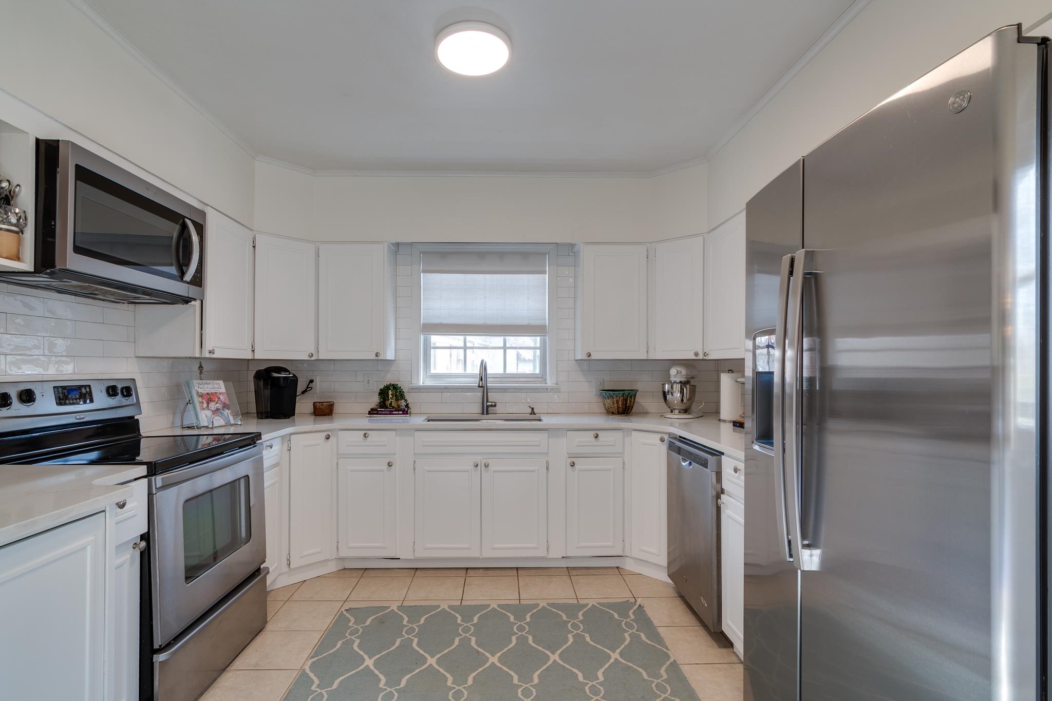 337 North White Station Road Memphis, TN 38117 - Photo 18 of 37 Kitchen with light tile patterned floors, stainless steel appliances, light countertops, white cabinets, and a sink