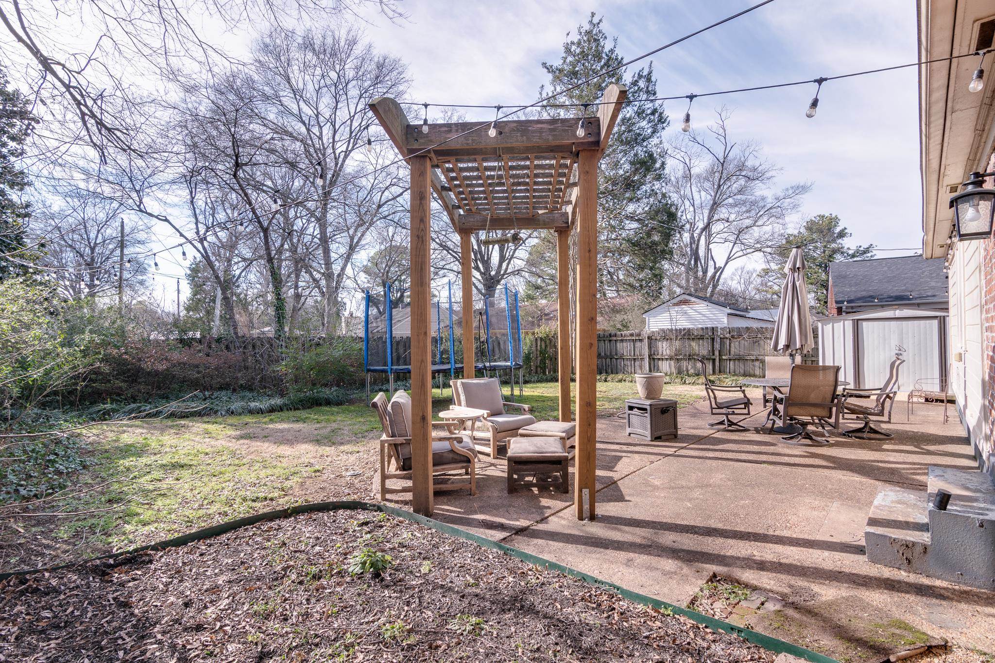 337 North White Station Road Memphis, TN 38117 - Photo 31 of 37 View of yard with a patio area, a fenced backyard, a trampoline, and outdoor dining space