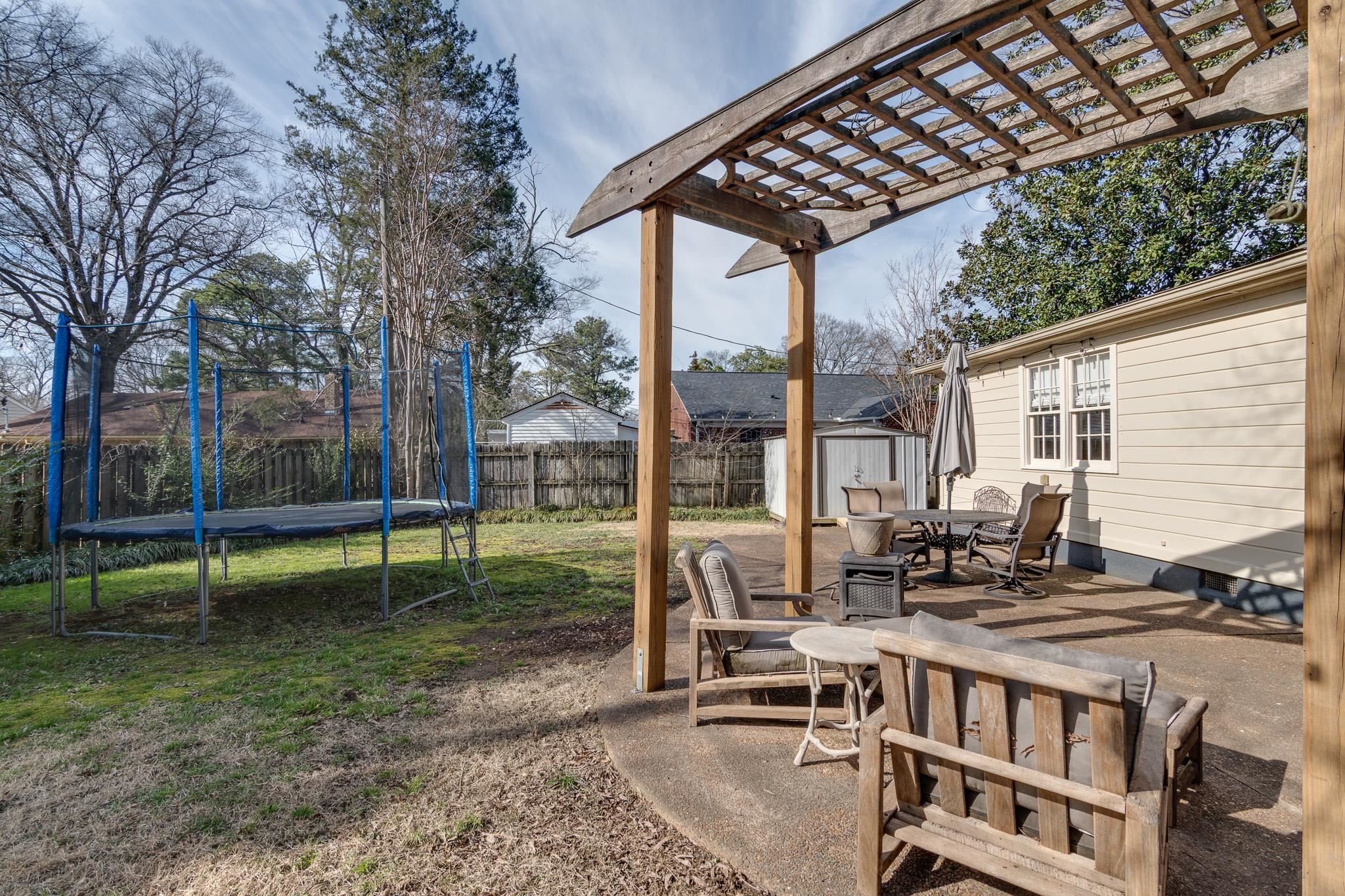 337 North White Station Road Memphis, TN 38117 - Photo 32 of 37 View of yard featuring a storage shed, a patio, an outbuilding, a trampoline, and outdoor dining space