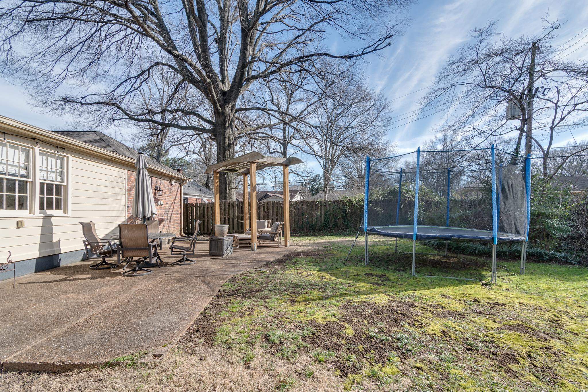 337 North White Station Road Memphis, TN 38117 - Photo 34 of 37 View of yard with a patio, a trampoline, and fence