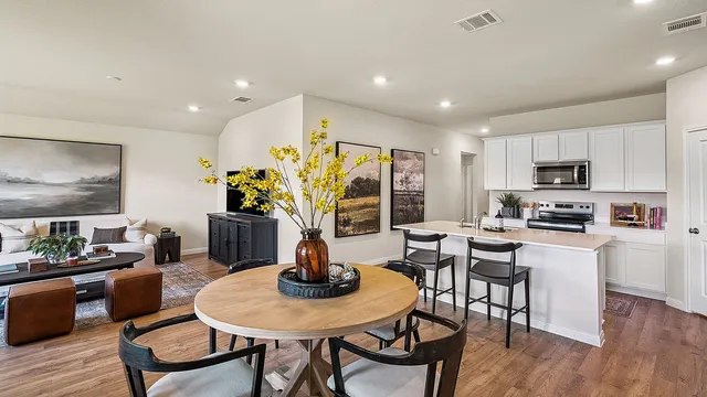 a kitchen with sink cabinets dining table and chairs