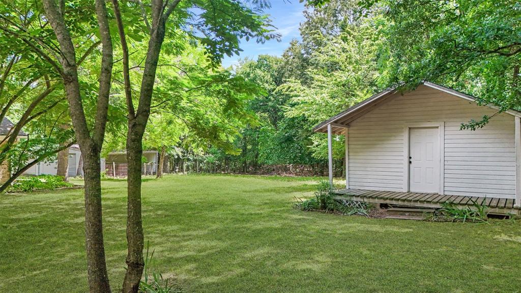 3870 County Road Arthur City, TX 75411 - Photo 32 of 39 Expansive green lawn featuring a separate ADU with a covered porch and white siding