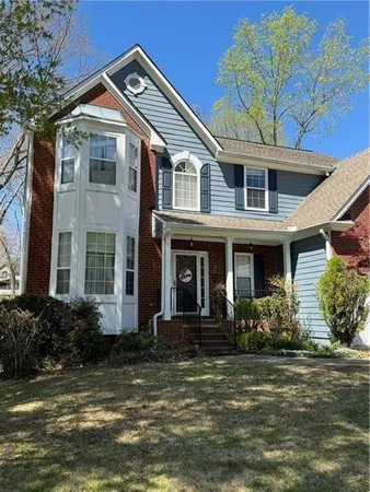 a front view of a house with lots of windows and plants