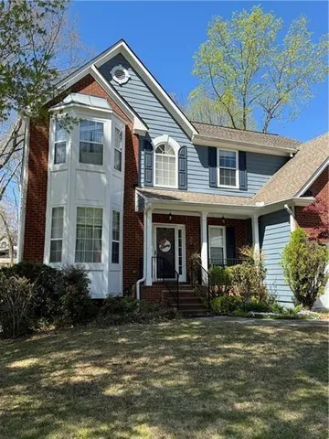 a front view of a house with lots of windows and plants