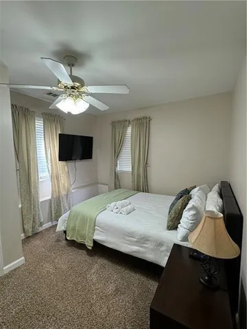 a spacious bedroom with a bed and a flat screen tv