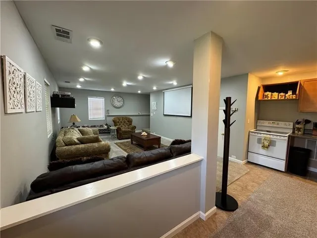 a view of a kitchen with furniture and stainless steel appliances