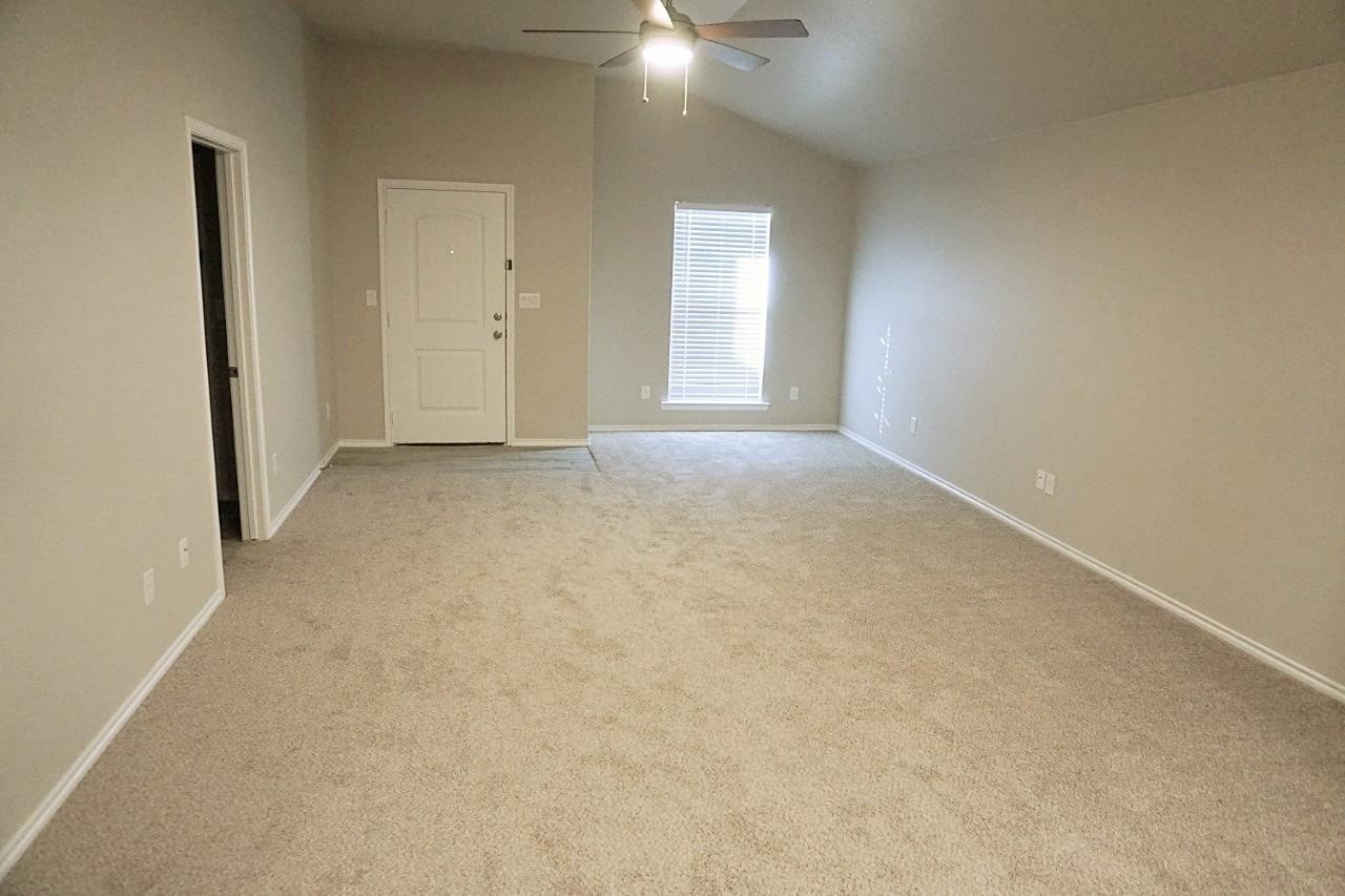 6822 40th Street Lubbock, TX 79407 - Photo 2 of 10 an empty room with windows and entrance to other room